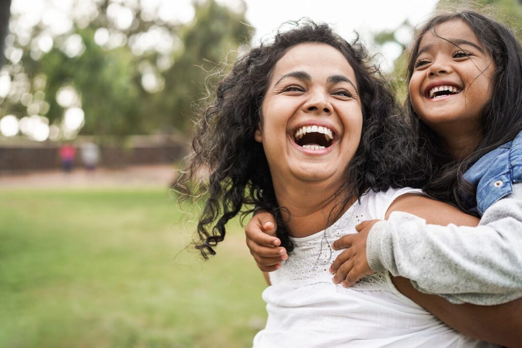 Happy indian mother having fun with her daughter outdoor